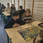 Grupa uczniów gra przy stolikach w planszówki..jpg