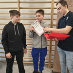 Mężczyzna wręcza dyplomy dwóm uczniom..jpg