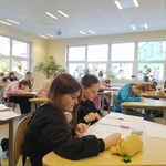 Dwie uczennice przy stoliku zapisują tekst na kartkach.jpg