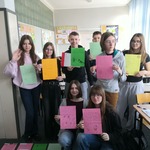 Uczniowie trzymają w rękach kolorowe kartki.jpg