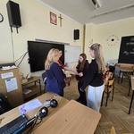 Dwie nauczycielki wręczają nagrody uczennicom w sali lekcyjnej.jpg