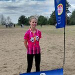 Dziewczyna w sportowym stroju stoi na łące_ przed nią napis 2..jpg
