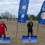 Trzech chłopców stoi przed banerami z liczbami i niebieskimi flagami.jpg