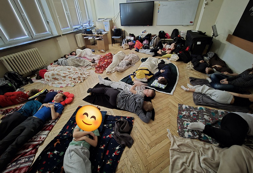 Grupa dzieci śpi na podłodze na kocach w sali lekcyjnej..jpg
