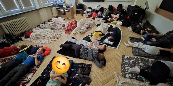 Grupa dzieci śpi na podłodze na kocach w sali lekcyjnej..jpg