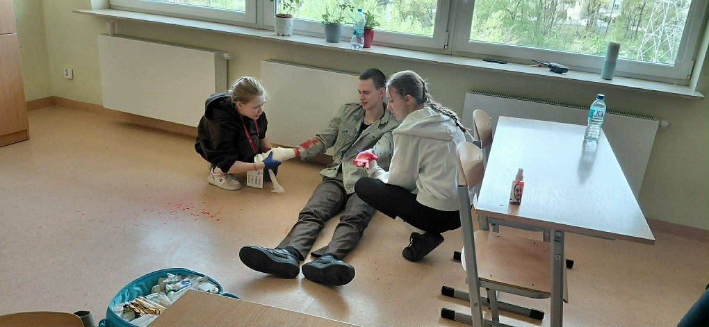 Dwie dziewczynki udzielają pierwszej pomocy chłopakowi..jpg