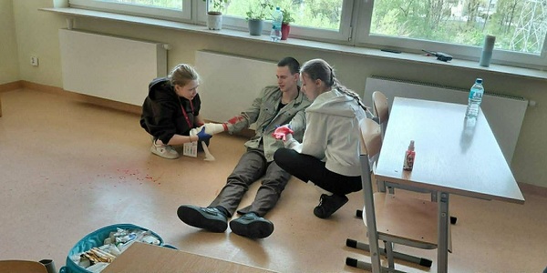 Dwie dziewczynki udzielają pierwszej pomocy chłopakowi..jpg