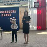 Wysoka dziewczna stoi z mikrofonem obok niskiej dziewczynki.jpg