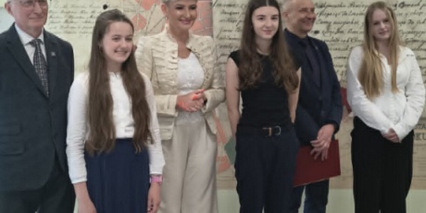 Trzy dziewczynki pozują do zdjęcia z p. kurator i pracownikami archiwum..jpg