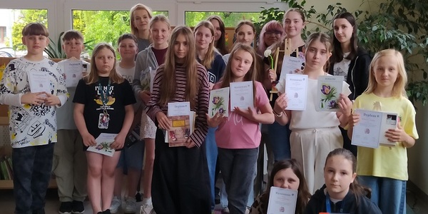 Grupa uczniów pozuje do zdjęcia z dyplomami w rękach.jpg