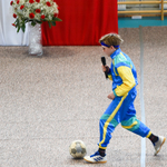 uczeń w dresach ortalionowych wbiega z piłką na scenę.jpg