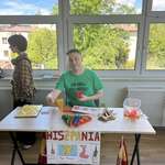 Mężczyzna w zielonej koszulce siedzi przy stoliku z napisem Hiszpania.jpg