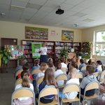 Pani dyrektor przemawia w bibliotece do dzieci siedzących na krzesłach..jpg