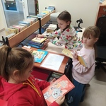 Trzy dziewczynki porządkują książki w bibliotece.jpg