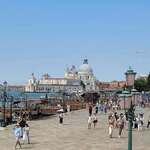 Widok na zabytkowy pałac_ w tle spacerujący ludzie przy promenadzie nad wodą..jpg