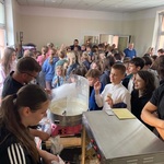 Grupa dzieci stoi przy maszynie z pop cornem i watą cukrową.jpg