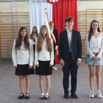 3 dziewczyny i chłopak pozują do zdjęcia na tle flagi Polski.jpg