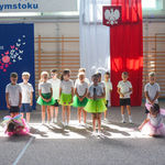 Grupa dzieci ubrana w kolorowe stroje występuje na hali.jpg