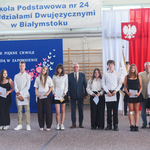 Grupa uczennic i uczniów elegancko ubranych pozuje do zdjęcia  z dyrektorem..jpg