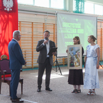 Mężczyzna przemawia do dyrektora_ obok stoją kobiety z obrazem w rękach..jpg
