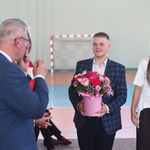 Uczeń z uczennicą niosą kwiaty w pudełku.jpg