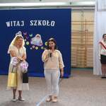 Dwie kobiety przemawiają_ w  tle napis Witaj szkoło i flaga polskia z godłem.jpg
