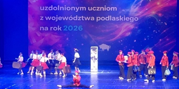 Grupa artystów na scenie z niebieskim światłem.jpg