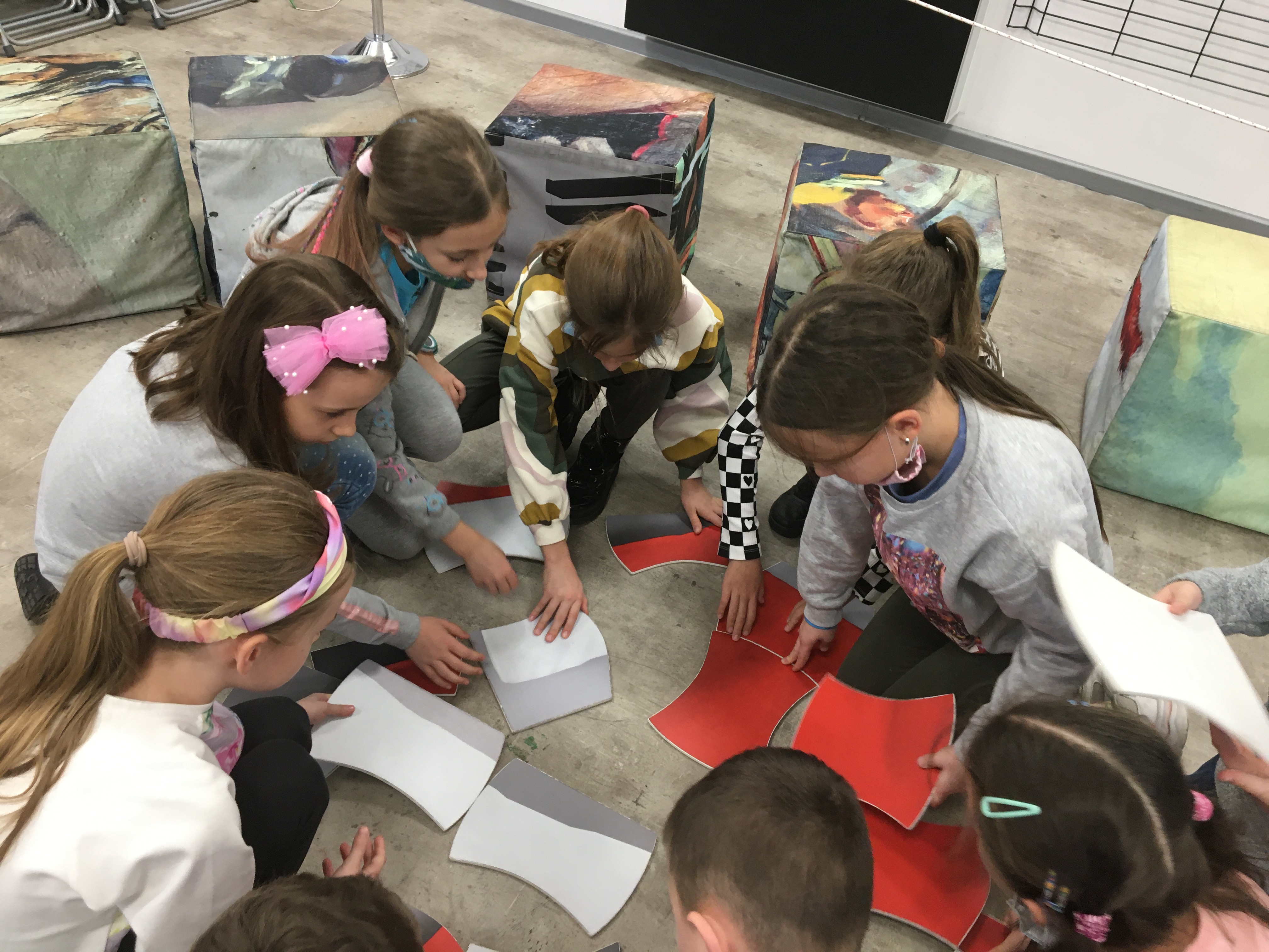 Uczniowie układający flagę polską z puzzli.