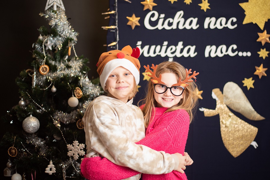 Zdjęcie świątecznie ubranych dziewczynek na tle napisu "Cicha noc..."