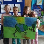 Dzieci trzymają plakat o ziemi.