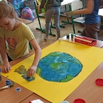 Uczniowie malują plakat na Dzień ziemi.