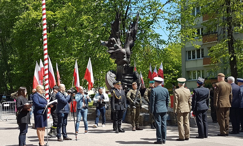 Żołnierze stojący pod pomnikiem.