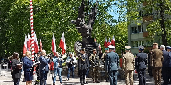 Żołnierze stojący pod pomnikiem.