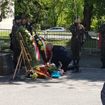 Pan dyrektor składający kwiaty pod pomnikiem.