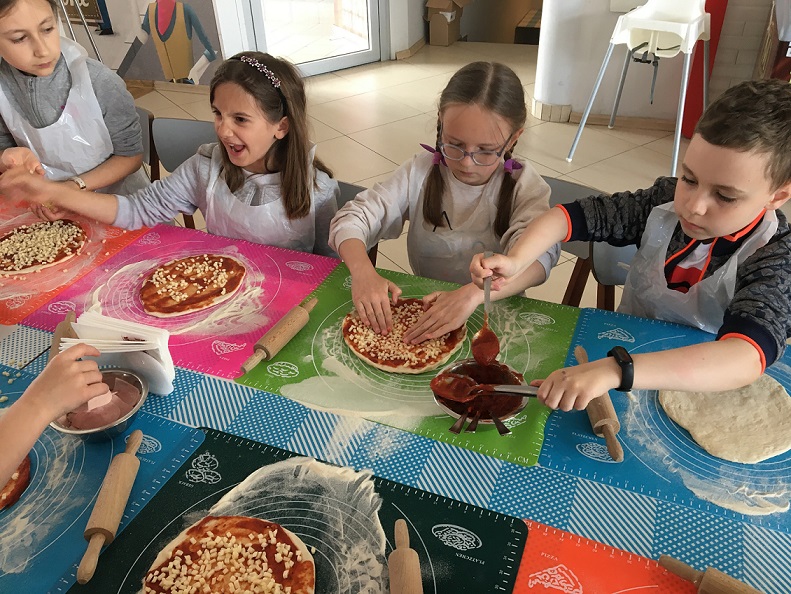 Uczniowie przygotowujący pizzę.