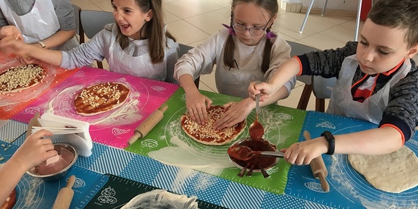 Uczniowie przygotowujący pizzę.