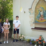 Uczniowie stoją przy kapliczce.