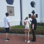 Uczniowie stoją przy tablicy pamiątkowej