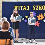 Prowadzący uczniowie przemawiają przez mikrofony.