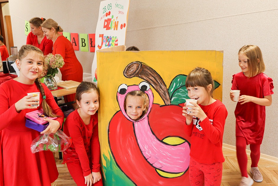 Dziewczynki na tle czerwonego jabłka.
