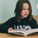 Zdjęcie dziewczyny czytającej książkę.