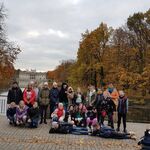 Zdjęcie klasowe, w tle Łazienki Królewskie, dookoła kolorowe drzewa.