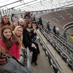 Zdjęcie uczniów na tle stadionu narodowego od wewnątrz.