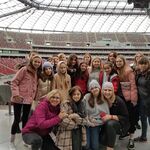 Zdjęcie uczniów na tle stadionu narodowego od wewnątrz.