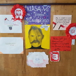 Brązowe drzwi klasy ozdobione plakatem z podobizną osoby oraz napisami..