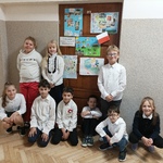 9 uczniów stoi przy drzwiach klasy lekcyjnej.