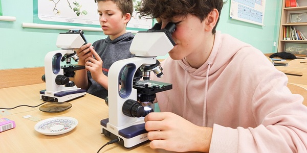 Uczniowie pracują na mikroskopach.