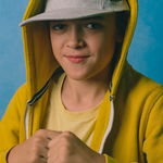 Portret chłopca w czapce z daszkiemi żółtej bluzie.