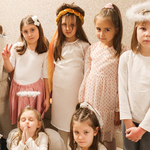 Dziewczynki ubrane na biało z aureolami i skrzydłami oraz przebrane za święte.