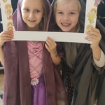 Dwie dziewczynki przebrane za święte robią zdjęcie w ramce.